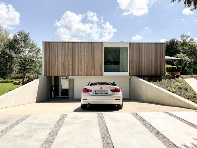 Prefab houtskeletbouw woning met kelder #144 van Skilpod. Afwerking in natuurhout en witte ramen.