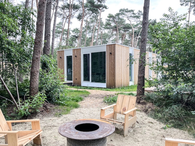 Prefab houtskeletbouw vakantiewoning prototype #80A van Skilpod. Afwerking in natuurhout en witte ramen.