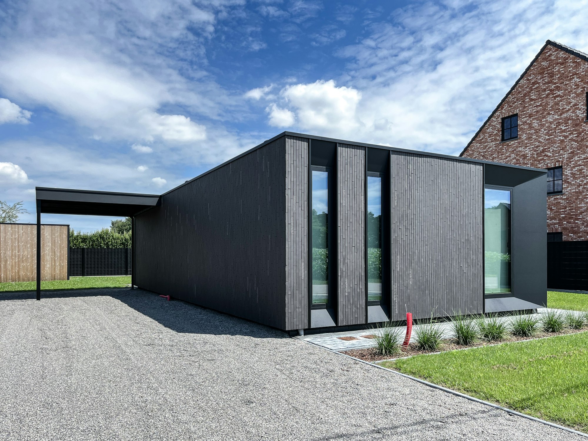 Skilpod #100 prefab bungalow woning met carport in zwarte steenstrips