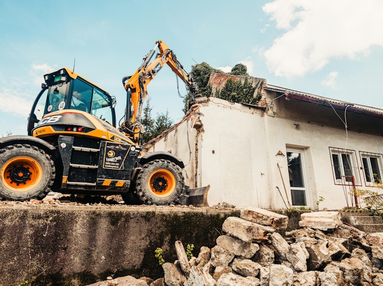 Machine breekt oude woning af