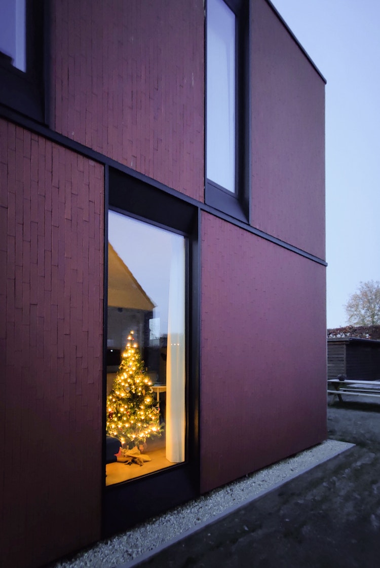 Woning met kerstboom achter het raam