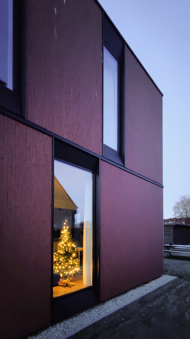 Woning met kerstboom achter het raam